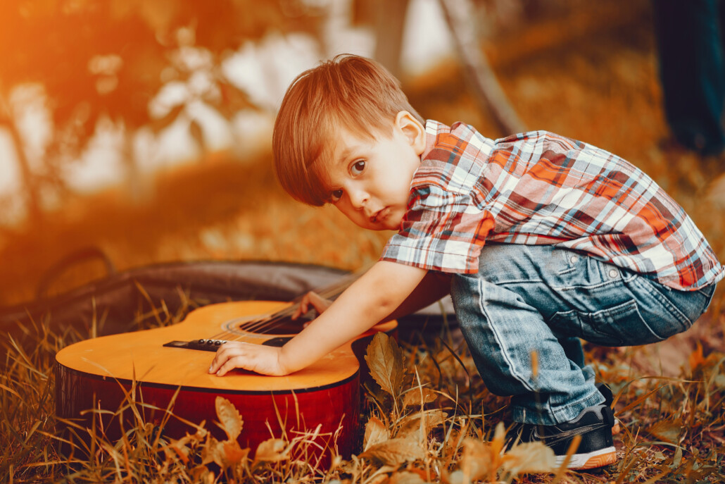 Cute little boy playing in a park 3. Musikalische Früherziehung an der Gitarre 1 Instrumente